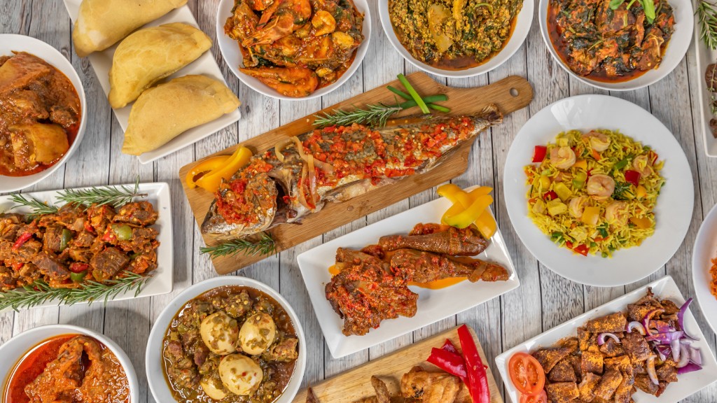 A colourful spread of Nigerian dishes including grilled fish, stews and sides